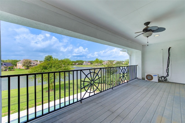 wooden terrace with a water view, a ceiling fan, and a yard