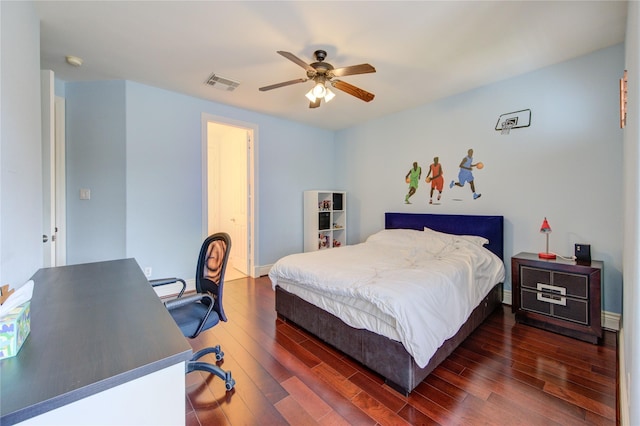 bedroom featuring baseboards, ceiling fan, visible vents, and wood finished floors