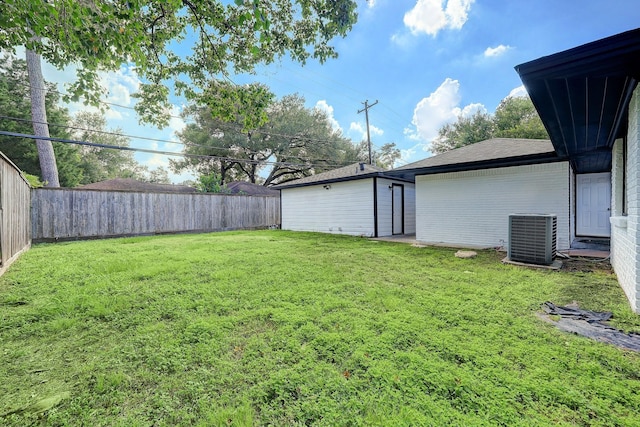 view of yard with a fenced backyard and central AC