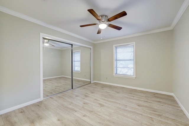 unfurnished bedroom with crown molding, baseboards, multiple windows, and wood finished floors