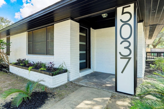 entrance to property featuring brick siding