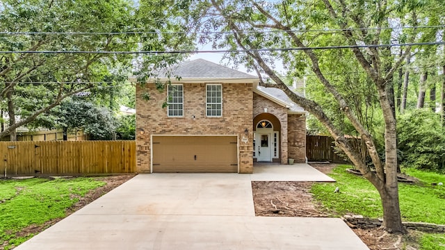 traditional-style home with fence, brick siding, a garage, a chimney, and driveway