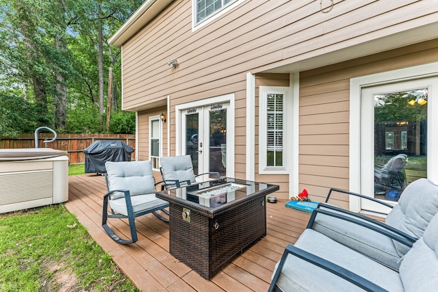 wooden deck featuring outdoor lounge area, grilling area, fence, and french doors