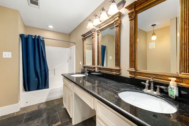 full bath featuring stone finish floor, shower / bath combo with shower curtain, visible vents, and a sink