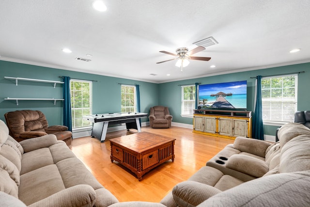 living area featuring crown molding, ceiling fan, and visible vents