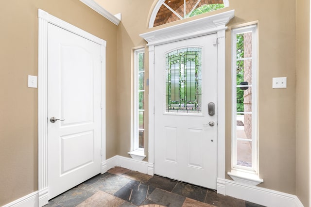 entryway featuring stone tile flooring and baseboards