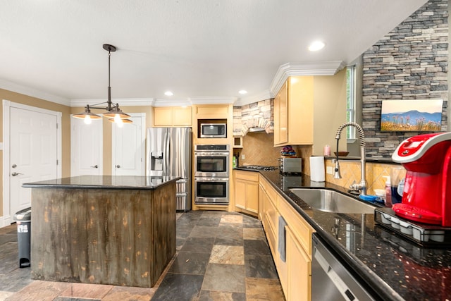 kitchen with a sink, stone finish floor, stainless steel appliances, tasteful backsplash, and ornamental molding