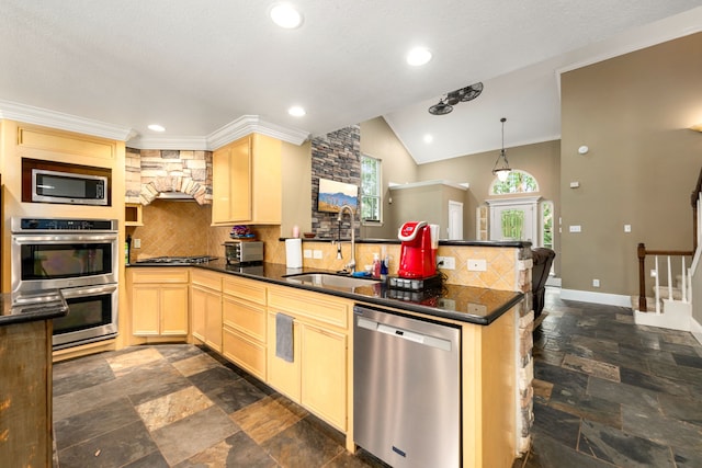 kitchen featuring dark countertops, appliances with stainless steel finishes, backsplash, and a peninsula