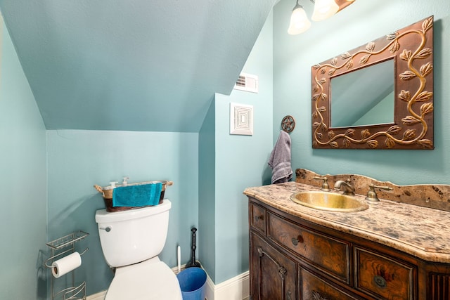 bathroom with vanity, vaulted ceiling, toilet, and visible vents