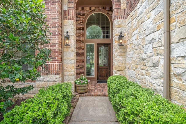 doorway to property with brick siding and stone siding
