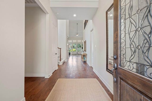 foyer entrance featuring baseboards, visible vents, dark wood finished floors, and stairs