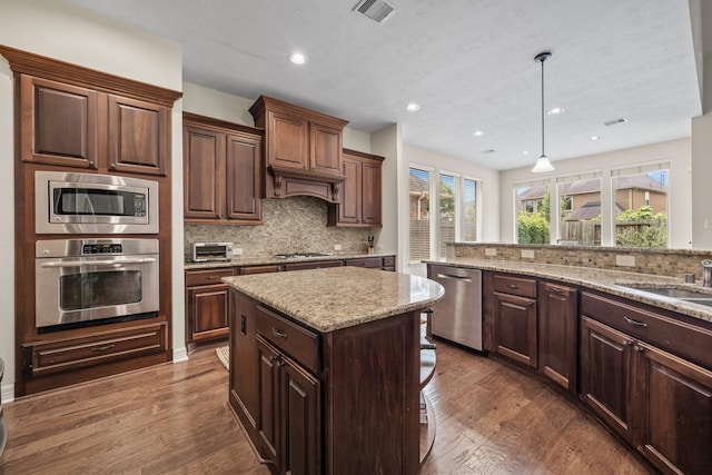 kitchen with tasteful backsplash, stainless steel appliances, and dark wood-type flooring