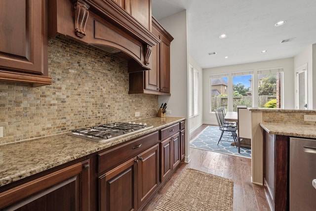 kitchen featuring visible vents, tasteful backsplash, dark wood-style floors, and stainless steel gas stovetop
