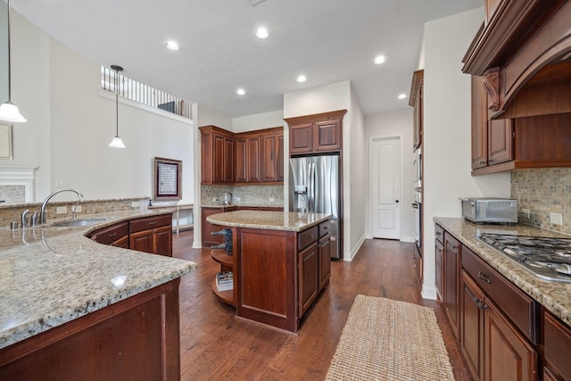 kitchen with open shelves, appliances with stainless steel finishes, a sink, tasteful backsplash, and a kitchen island