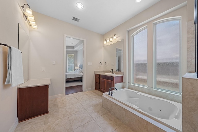 ensuite bathroom with connected bathroom, vanity, tile patterned floors, a jetted tub, and visible vents