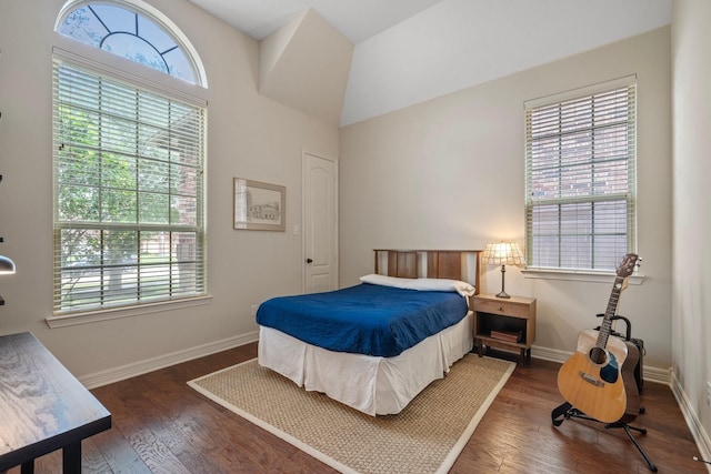 bedroom with baseboards, multiple windows, and wood finished floors