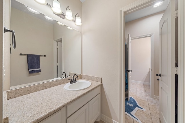 bathroom with tile patterned floors, baseboards, and vanity