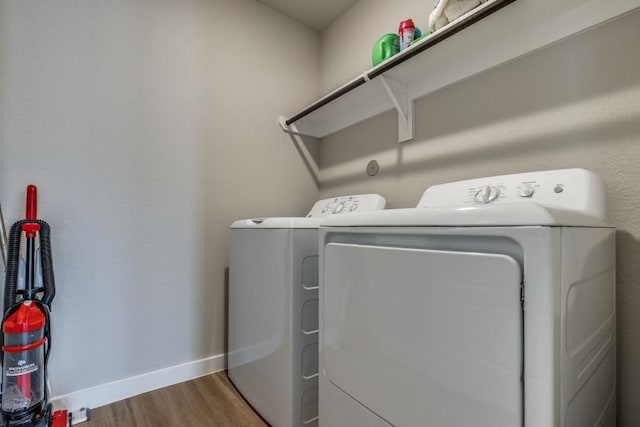 949 Gentle Moss Dr, Magnolia, TX 77354 - washroom with baseboards, laundry area, washer and clothes dryer, and wood finished floors