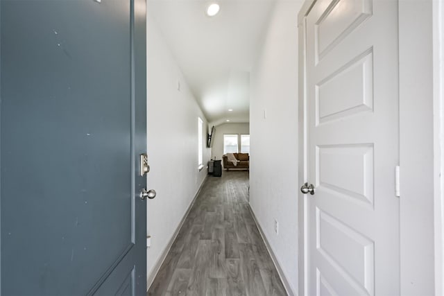 hall featuring baseboards, recessed lighting, and wood finished floors