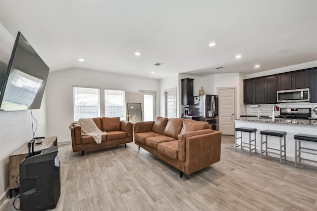 living area featuring recessed lighting, light wood-style flooring, lofted ceiling, and visible vents