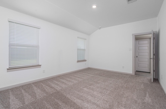 spare room featuring vaulted ceiling, baseboards, and carpet flooring