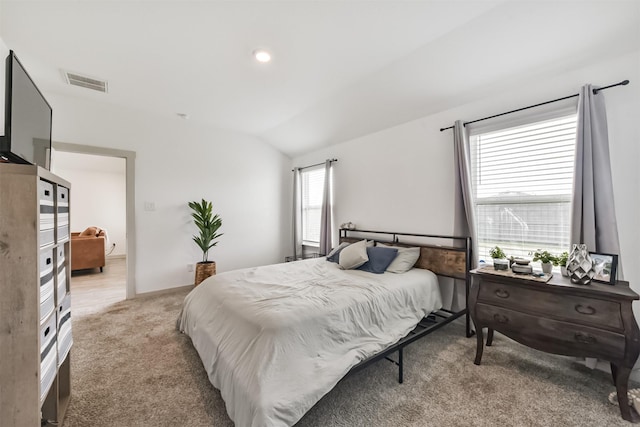 bedroom featuring visible vents, vaulted ceiling, and light colored carpet