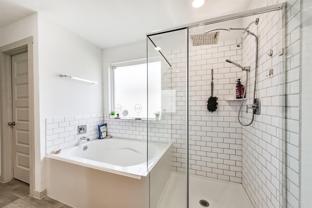 bathroom featuring a bath and a shower stall