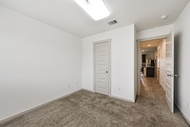 unfurnished bedroom featuring baseboards, carpet, recessed lighting, and visible vents