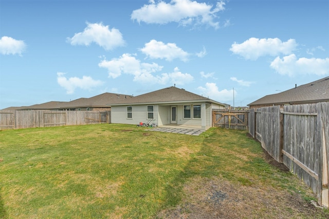 rear view of property featuring a patio, a fenced backyard, and a yard