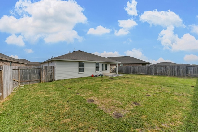 rear view of house featuring a fenced backyard, a patio, and a yard
