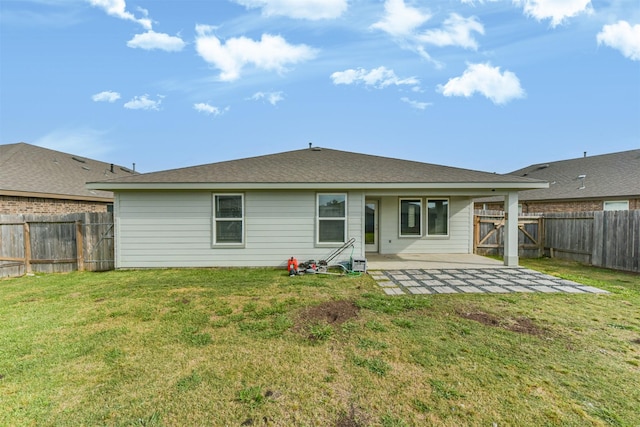 rear view of house featuring a lawn, a fenced backyard, and a patio area