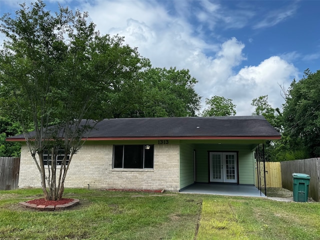 back of house featuring fence, french doors, brick siding, a patio area, and a yard