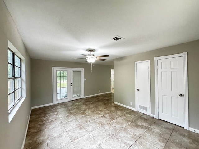 unfurnished room with baseboards, a ceiling fan, and visible vents