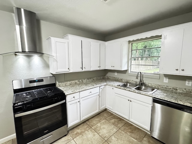 kitchen featuring a sink, appliances with stainless steel finishes, wall chimney range hood, and light countertops