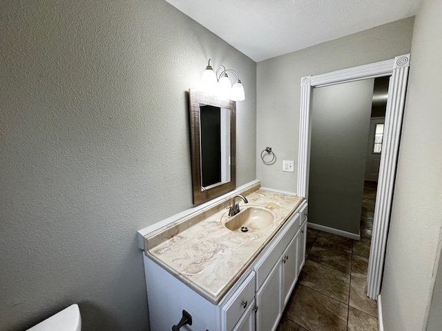 bathroom featuring vanity, baseboards, and toilet