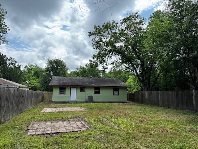 rear view of house with central air condition unit, a patio, a yard, and a fenced backyard