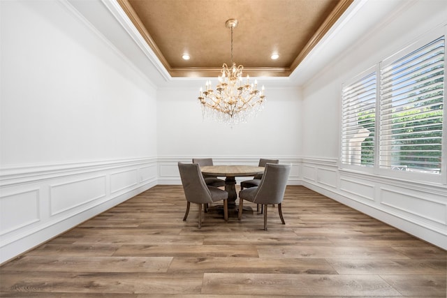 13614 Boerne Canyon Ln, Cypress, TX 77429 - dining room with a tray ceiling, wood finished floors, a chandelier, crown molding, and a decorative wall