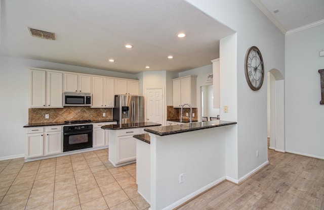 18611 Camellia Estates Ln, Cypress, TX 77429 - kitchen with backsplash, stainless steel appliances, a sink, and a peninsula