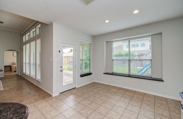 18611 Camellia Estates Ln, Cypress, TX 77429 - doorway featuring crown molding, light tile patterned flooring, arched walkways, recessed lighting, and baseboards