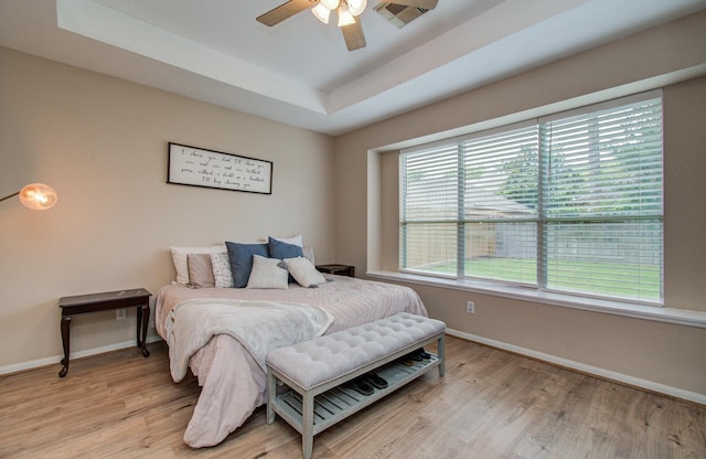 18611 Camellia Estates Ln, Cypress, TX 77429 - bedroom with baseboards, visible vents, light wood-style flooring, and a tray ceiling
