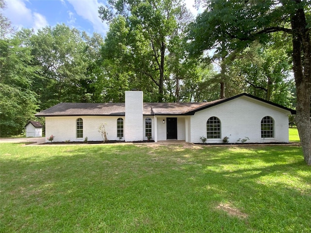 ranch-style house with brick siding, a chimney, and a front lawn