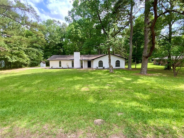 view of front of home featuring a chimney and a front lawn