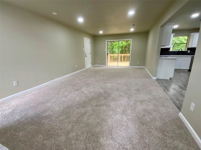 unfurnished living room with light colored carpet, recessed lighting, baseboards, and visible vents