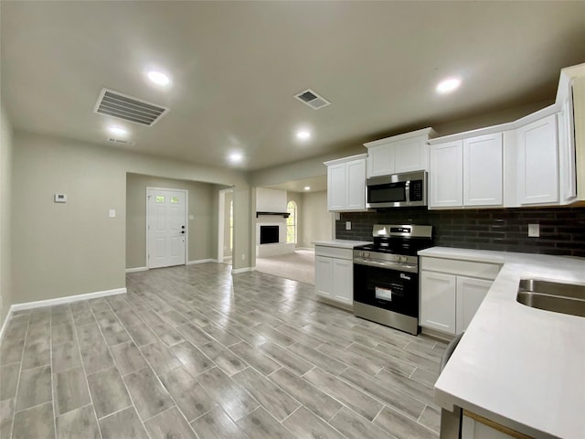 kitchen with visible vents, decorative backsplash, appliances with stainless steel finishes, and light countertops