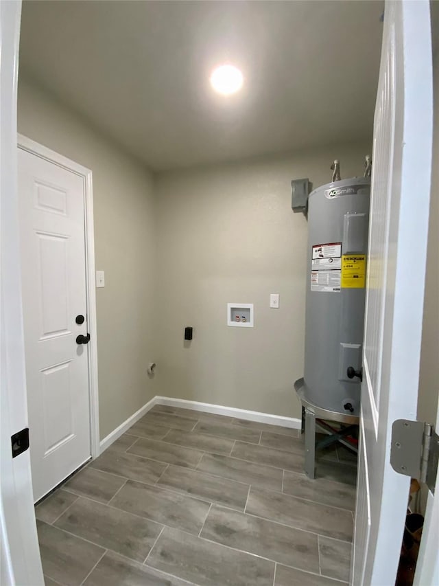 clothes washing area featuring laundry area, baseboards, water heater, and electric dryer hookup