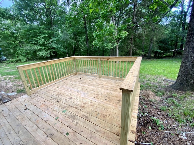 wooden deck featuring a lawn