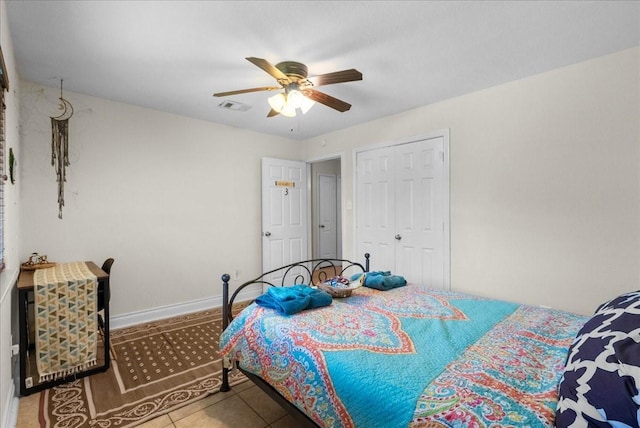 tiled bedroom with a closet, baseboards, a ceiling fan, and visible vents