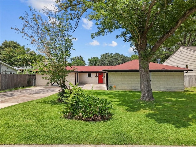 single story home with brick siding, a front lawn, fence, and concrete driveway