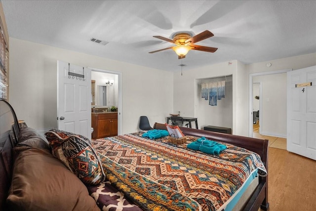 bedroom featuring ceiling fan, visible vents, and light wood finished floors