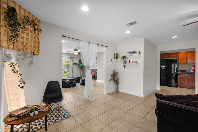 interior space featuring visible vents, a ceiling fan, baseboards, and light tile patterned floors